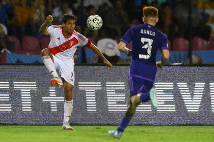 Emilio Saba controla el balón; lo persigue Barco, la víctima del penal