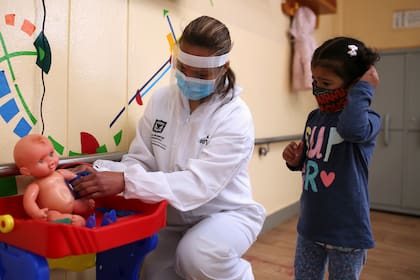 Emily Quintero, de 3 años, juega con su maestra, en un jardín de infantes, durante la reactivación de varios sectores económicos tras el fin de la cuarentena por la enfermedad del coronavirus (COVID-19), en Bogotá.