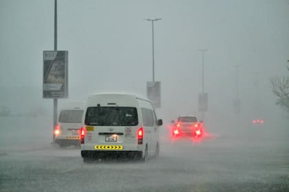 Los vehículos circulan por una carretera inundada durante lluvias torrenciales en Dubai el 16 de abril de 2024. 