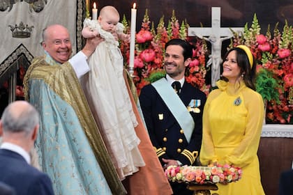 Emoción por partida doble: el día del bautismo, los príncipes Carlos Felipe y Sofía cumplían su décimo aniversario de casados. Para el evento, el hijo del Rey lució el traje con sus condecoraciones; y su mujer, un diseño con cuello alto, mangas abullonadas y falda en capas diseñado por Lars Wallin… y en un color poco habitual para un bautismo. Lució, además, los mismos pendientes que usó para su boda, diez años atrás.