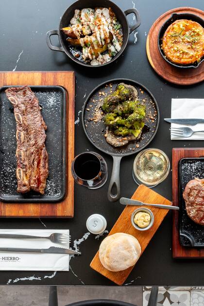 Empanadas de carne, cordero y humita se presentan junto a morcilla vasca y mollejas reinterpretadas, mientras la chuleta de berenjena frita y la provoleta con ananá grillado ofrecen su contrapunto vegetal