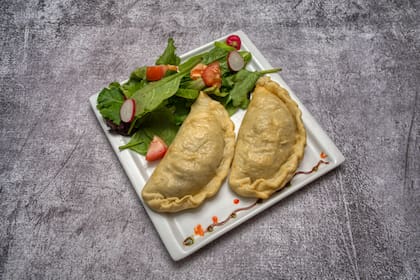 Empanadas de carne cortada a cuchillo, servidas con ensalada fresca