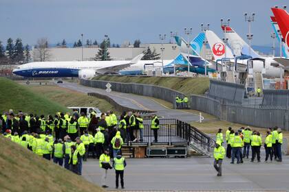 Empleados de Boeing observan la partida del avión