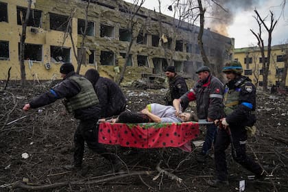 Empleados de emergencia y policías ucranianos evacuan a Iryna Kalinina, embarazada y herida, de un hospital de maternidad dañado por un ataque aéreo ruso en Mariupol, Ucrania, el 9 de marzo de 2022.