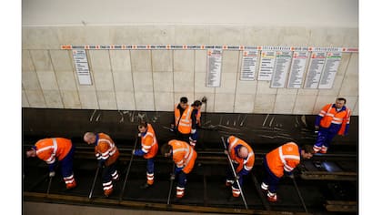 Empleados traban en la reparación de la vía férrea en la estación de metro Sukharevskaya en Moscú, Rusia
