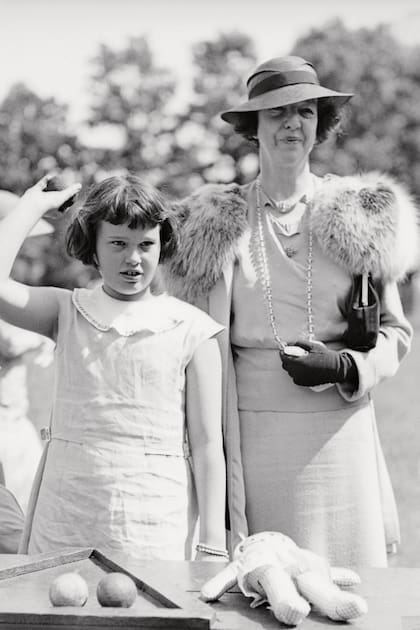 En 1935, a los 11 años, junto a Gertrude Vanderbilt, su tía y tutora, lanzando pelotas de béisbol en una feria benéfica.