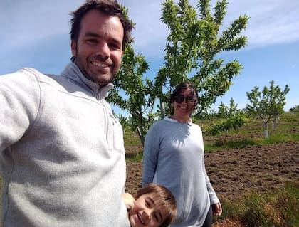 En 2018, Diego Irastorza junto a su mujer Carina y su hijo Antonio. Detrás las plantaciones de almendros