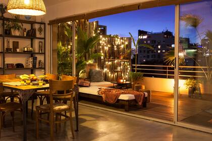 En Belgrano, este balcón aterrazado captura la esencia del sudeste asiático y se conecta completamente con el interior. Atención al divisor de cañas de distinta altura iluminado. Un gran efecto con poco.