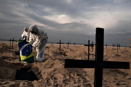 En Brasil cavan tumbas en la playa de Copacabana para honrar a los muertos y protestar contra Jair Bolsonaro