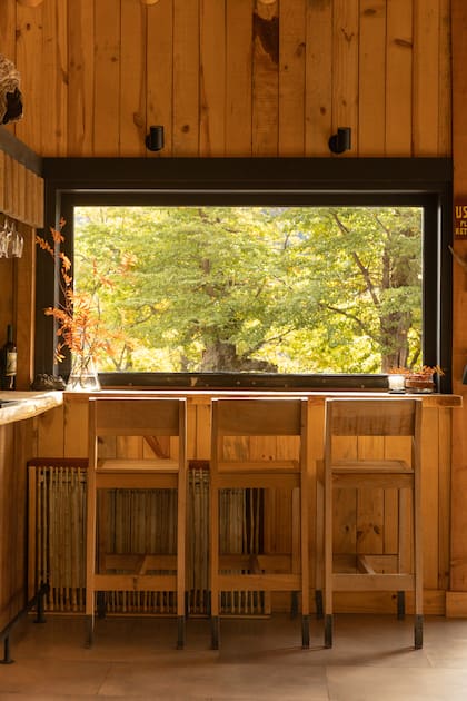 En cada rincón de la casa abunda la madera y el entorno se hace presente a través de los ventanales.