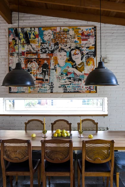 En casa de la ceramista Carola Malbrán, mesa (Carpintería López) con sillas de esterillados diferentes (Mercado de Pulgas). Galponeras pintadas de negro por fuera y cobre por dentro. Cuadro de Tester