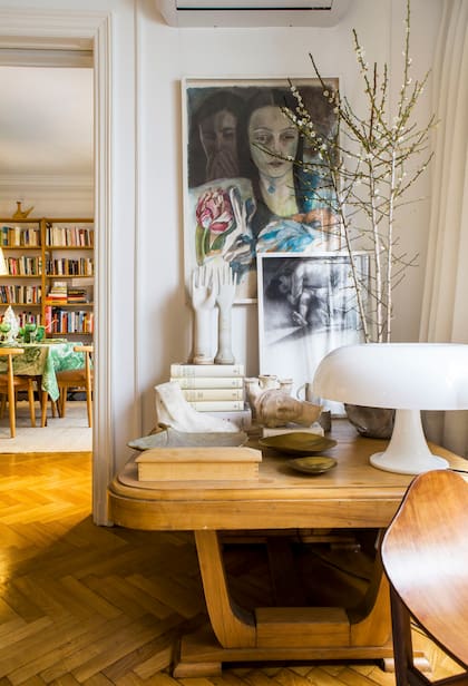 En casa de María José Rojas, su talento para mezclar muebles y objetos vintage con un aire fresco. Sobre la mesa antigua art déco, antiguos moldes de guantes como escultura; lámpara ‘Nessino’, diseño de los años 60 de la firma italiana Artemide, y cuadros pintados por ella.