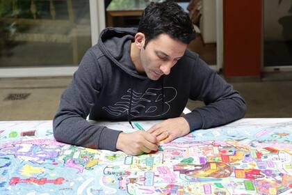 En casa. Juan Minujín, en pleno trabajo con sus mapas