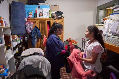 EN CASA. Yamila vive junto a sus hijas en una habitación de hotel por la que paga 50.000 pesos por mes. Cuando llegan, se guardan uniforme y guardapolvos hasta el otro día. Después de merendar, las tres se ocupan de sus estudios