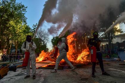 En chile: saqueos e incendios en una masiva marcha por el aniversario de las protestas (Photo by Martin BERNETTI / AFP)