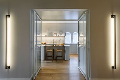 En el acceso a la cocina, apliques lineales de pared (Huup).