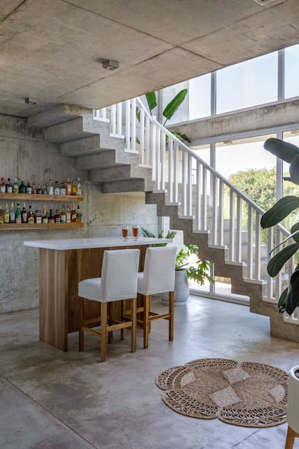 En el bajo escalera instalaron una barra que se conecta con la cocina.