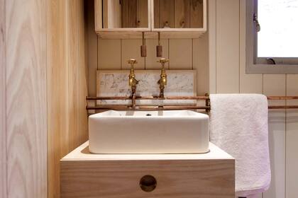 En el baño, bacha rectangular sobre un mueble de madera.