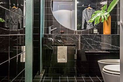 En el baño de la suite, las paredes y el piso se revistieron con azulejos negros con junta tomada en pastina blanca, al igual que en el toilette.