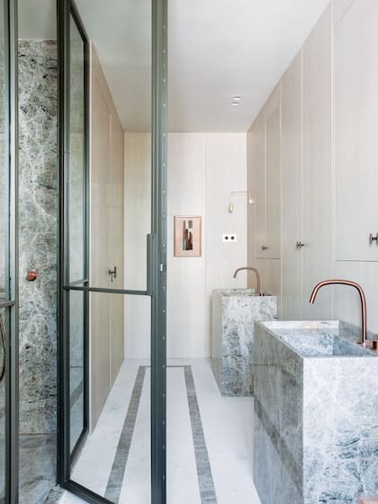 En el baño en suite, para dos, cada uno tiene su lavatorio, bien separado, cual monolitos de mármol.