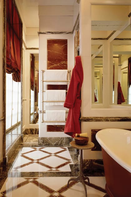En el baño principal de los apartamentos privados, las paredes y los pisos están cubiertos de mármol italiano rojo y blanco, mientras que los zócalos, molduras y cenefas son de ónix gris cebra.