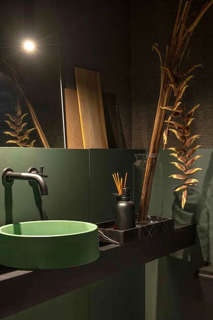 En el baño se apostó por el verde, complemento perfecto para el bordeaux.