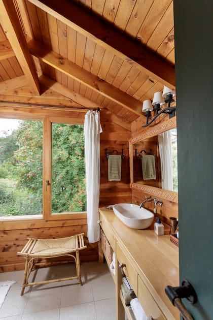 En el baño, se hizo un mueble que toma el largo de la pared para apoyar la bacha y tener lugar de guardado. Lo acompaña un espejo de medidas similares.