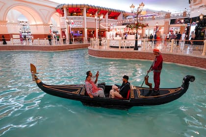 En el Centro Comercial Villaggio, el agua fluye como un río mientras los visitantes hacen compras