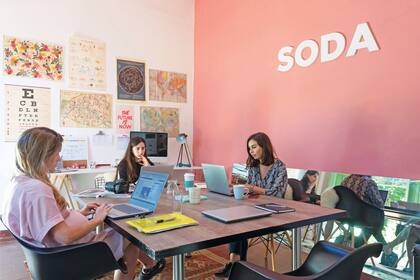 En el centro del cuarto, mesa hecha a medida para trabajar en ronda con sillas Eames y Bertoia. En las paredes, láminas, croquis y mapas.
