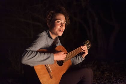 En El Churqui, Elise Herzog toca la guitarra la última noche.