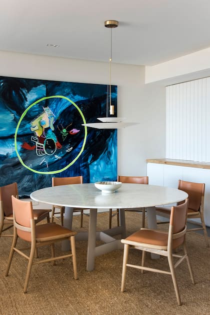 En el comedor, acrílico sobre tela de la argentina Magalí Milkis, mesa ‘Alex’ con tapa de mármol de Carrara y sillas de la colección ‘Jens’ (todo de B&B Italia).