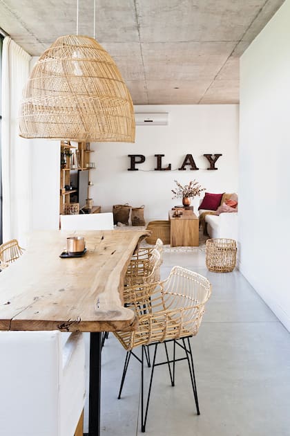 En el comedor diario, que se conecta con la cocina y playroom, se destaca la mesa de ciprés y las sillas de mimbre natural y hierro
