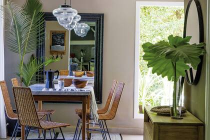 En el comedor diario, mesa de petirib con tapa de mrmol de Carrara y sillas de mimbre. Lmparas colgantes Ferroviarias y espejo con marco negro (todo de Galpn 8).