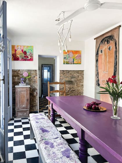En el comedor, una mesa de trabajo comprada en un remate, pintada de violeta intenso por la artista. Un gran cuadro de Celia Basavilbaso se combinó con dos de Goñi.