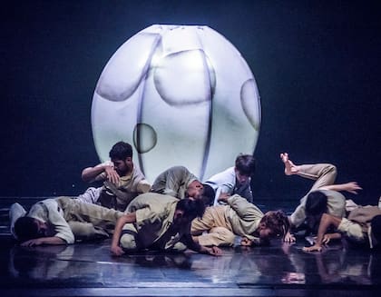 En el comienzo, una docena de bailarines surgen como zombies, rolan, se levantan, rebotan y vuelven a caer sobre el polvo