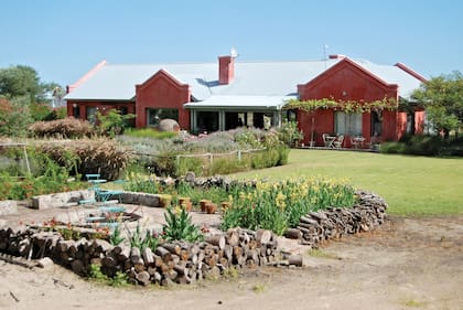 En el contrafrente, un fogón rodeado de lirios y amapolas, cerrado con un “cerco” de troncos con los que se alimentan ése y todos los fuegos de la casa (parrilla y chimeneas varias).