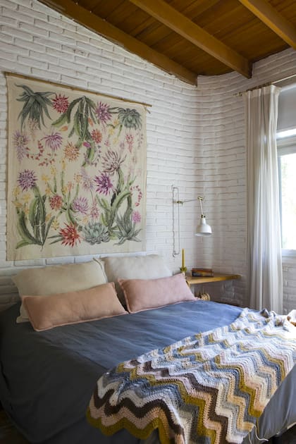 En el cuarto de la ceramista Caro Malbrán, tapiz de cactus en flor traído de un viaje y colcha multicolor en crochet.