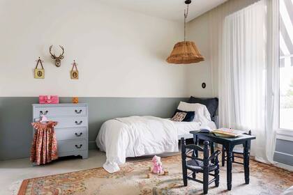 En el cuarto de la más pequeña, ropa de cama (Angelina Linen), lámpara de tela hecha por Anita y alfombra heredada. Las paredes bicolor siguen la paleta elegida para el resto de la casa.