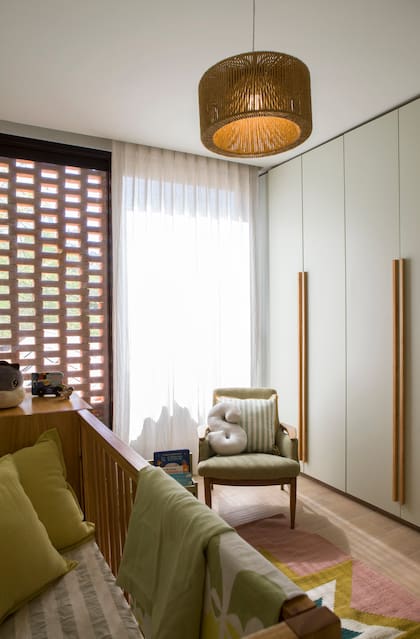 En el cuarto del más chiquito, cuna de madera con manta (Mercedes Segura Deco). Alfombra ‘Estrella’ (Seara Ñañay). Placard a medida (San Isidro Interiores).