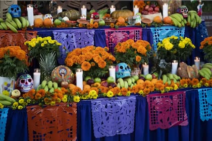 En el Día de Muertos las familias mexicanas hacen ofrendas y altares decorados con flores, papel picado, calaveras de azúcar, pan de muerto, mole y platos de comida (Fuente: Nick Agro)