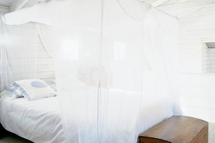 En el dormitorio, cama con dosel con paños de gasa, los mismos que caen por la baranda que da al living. Privacidad asegurada.
