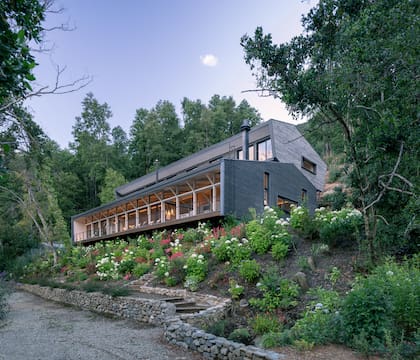 En el espacio que queda por debajo de la losa principal, entre los pilotes, aprovecharon para crear espacios de guardado para las cosas de la playa y el jardín, y un sector de juegos.