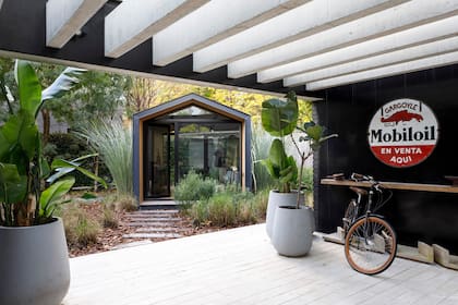 En el espacio semicubierto, bicicletero. Arriba, otro cartel vintage recuperado.