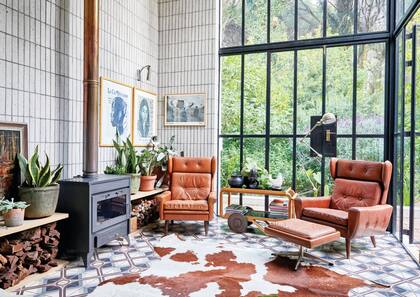 En el estar, el revestimiento de ladrillos se colocó de modo vertical, y el larguísimo tiraje cobrizo de la salamandra se lleva más miradas que el fuego.