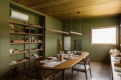 En el estudio, mesa, sillas, biblioteca y lámpara (todo de Talleres Sustentables). Sobre la pared, papeles de Mercedes Costal.