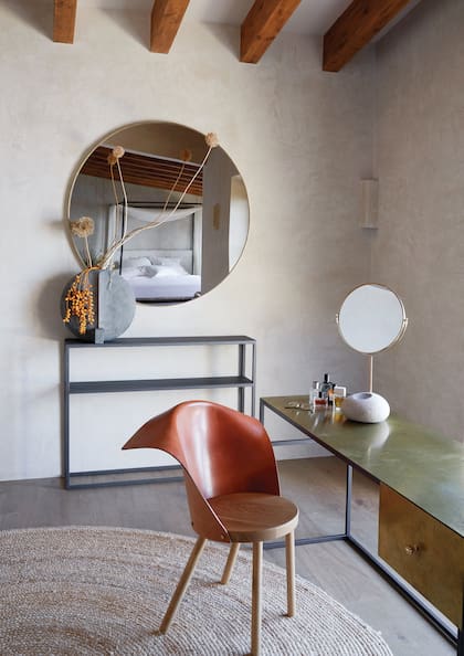 En el extremo del cuarto principal (la cama se refleja en el espejo circular), una mesa le da al maquillaje o a un escritorio