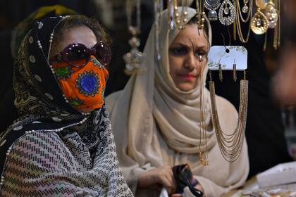 Mujeres eligen joyas en un comercio de Karachi