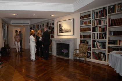 En el fondo, la obra fotográfica de Vicky Aguirre en la biblioteca deFranco Macri.