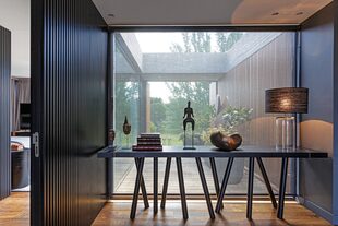 Piezas adquiridas en viajes y lámpara con pantalla de rafia negra (Paul French Gallery). Piso de roble de Eslavonia con veta negra (Patagonia Flooring).