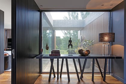 Piezas adquiridas en viajes y lámpara con pantalla de rafia negra (Paul French Gallery). Piso de roble de Eslavonia con veta negra (Patagonia Flooring).